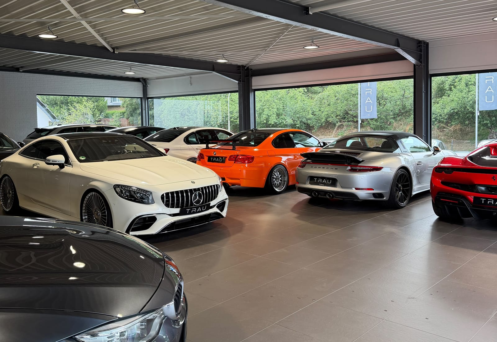 Ausstellungshalle der TRAU GmbH mit Mercedes-AMG, BMW M und Porsche 911